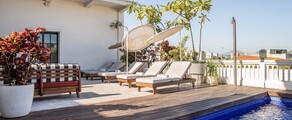 Piscine sur le toit avec vue sur la skyline, chaises longues.