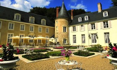 Val De Loire : château élégant, jardin soigné, ciel bleu.