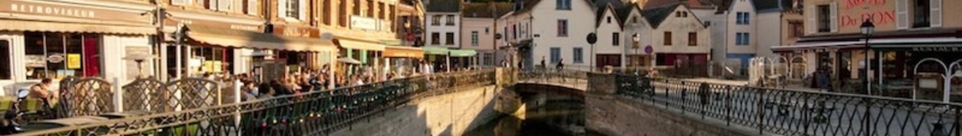 Amiens Glisy : Canal pittoresque avec café et église.