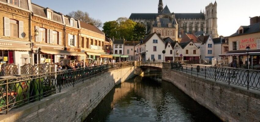 Amiens Glisy : Canal pittoresque avec café et église.