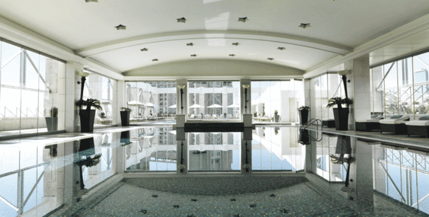 Espace piscine intérieure avec fenêtres et plafond courbé