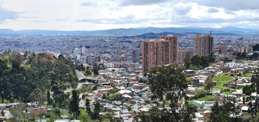 Ville avec vue panoramique sur montagnes et verdure.