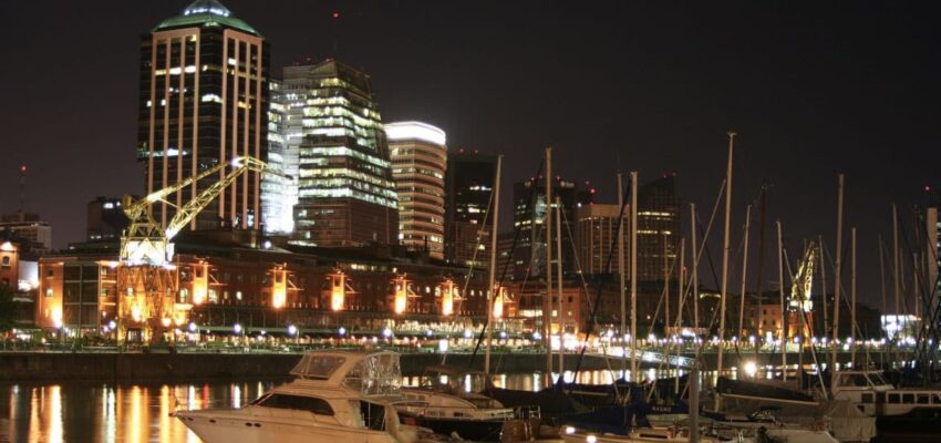 Cityscape nocturne – gratte-ciels illuminés et reflets sur l'eau.