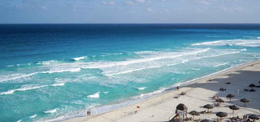 plage ensoleillée avec parasols et vagues turquoises