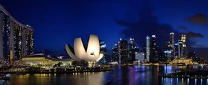Singapour : Marina Bay de nuit avec gratte-ciels illuminés.