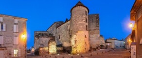 Cognac Châteaubernard fort et tour ronde illuminée au crépuscule.