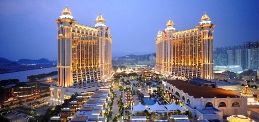 Grand hôtel et casino avec tours jumelles illuminées.