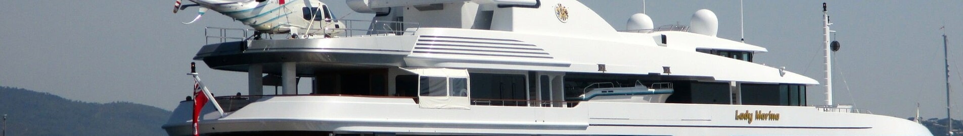 yacht luxe avec petit bateau et hélicoptère sur pont