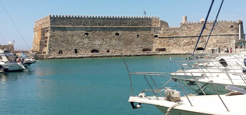 forteresse historique, eau turquoise, bateaux blancs sous ciel bleu.