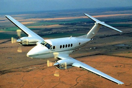 location de jet privé, avion bimoteur survolant des champs