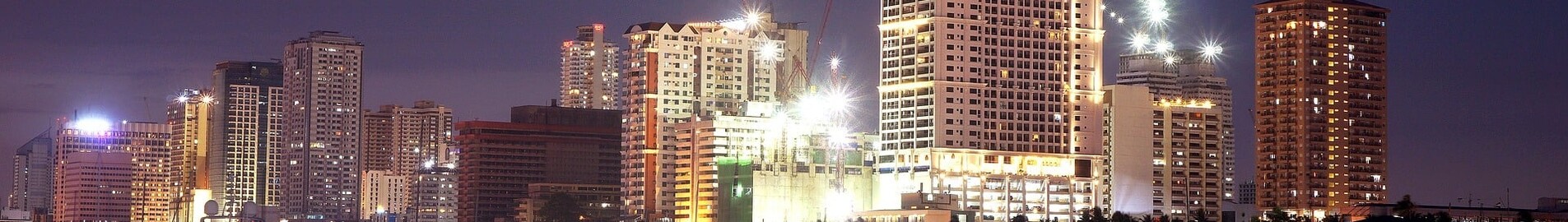 Manille : location de jet privé, skyline illuminée au crépuscule