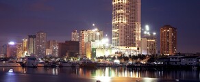 Manille : location de jet privé, skyline illuminée au crépuscule