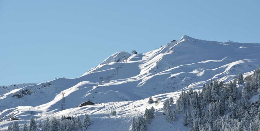 Sommet du ski : Montagne enneigée avec télésièges sous ciel bleu.