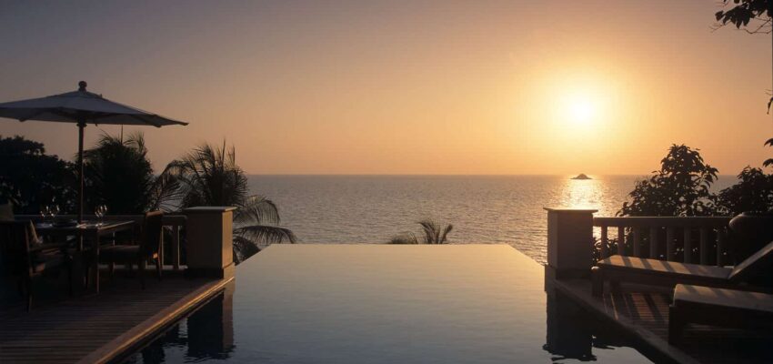 Piscine à débordement : coucher de soleil tropical océan et patio.