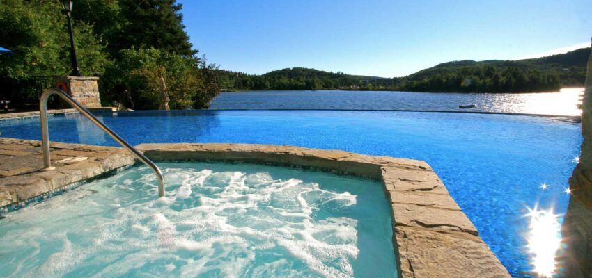 Jacuzzi avec vue sur piscine et lac paisible.