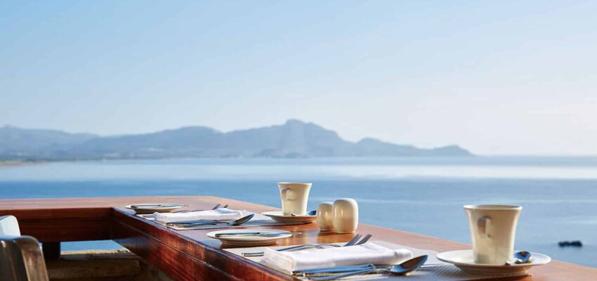 table à manger au bord de l'océan avec vue sur la montagne