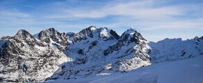 Saint-Moritz - Samedan, montagnes enneigées, ciel bleu clair.
