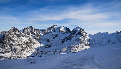 Saint-Moritz - Samedan, montagnes enneigées, ciel bleu clair.