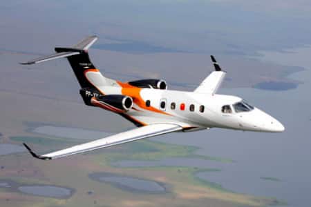 Location de jet privé : jet blanc survolant paysage.