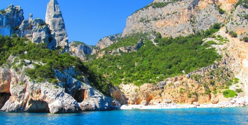 Alghero Fertilia : falaises, végétation, mer bleue.