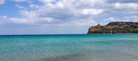 Location de jet privé: plage de sable, eau turquoise, ciel nuageux