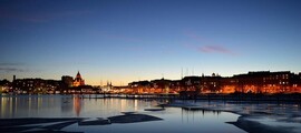 Helsinki crépuscule : Front de mer serein, immeubles illuminés.