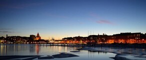 Helsinki crépuscule : Front de mer serein, immeubles illuminés.
