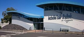 Aéroport Béziers Cap d'Agde : Bâtiment moderne, toit ondulé.