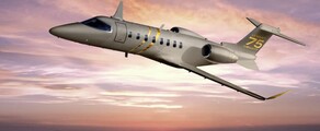 Jet privé Learjet 75 en vol, couché de soleil rosé