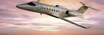 Jet privé Learjet 75 en vol, couché de soleil rosé