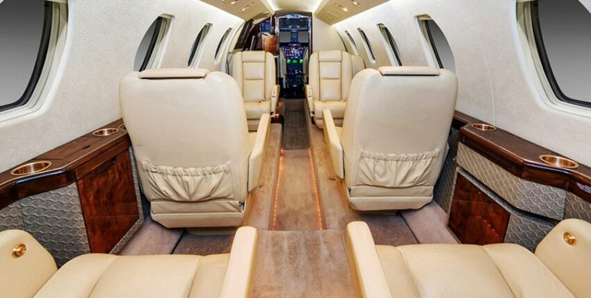 **location de jet privé** Luxueux intérieur beige avec accents bois.