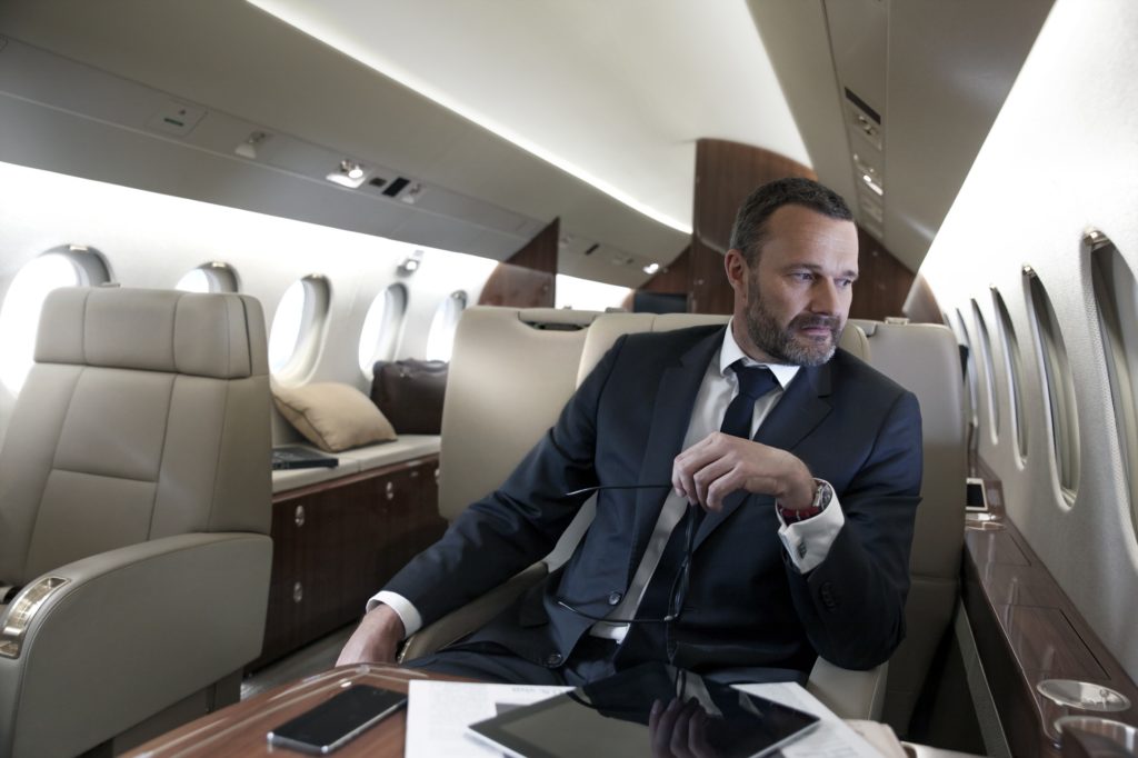 location de jet privé : Homme en costume dans un avion