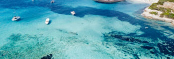 Eau turquoise avec des bateaux, plage en Corse
