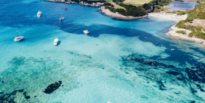 Eau turquoise avec des bateaux, plage en Corse