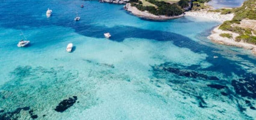 Eau turquoise avec des bateaux, plage en Corse