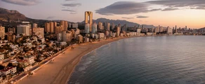 **Alicante Elche au coucher du soleil, la mer au premier plan.**