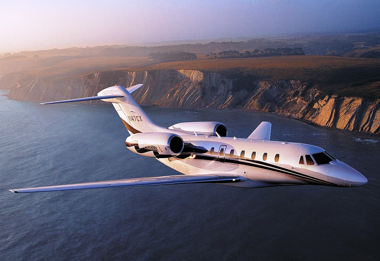 Le Cessna Citation X+ qui vole au milieu d'un magnifique paysage