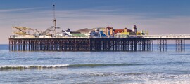 Brighton : jetée, mer calme, ciel dégagé, plage de galets.