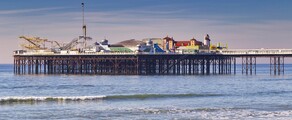 Brighton : jetée, mer calme, ciel dégagé, plage de galets.