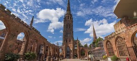 Ruines de la cathédrale de Coventry, ciel bleu, personnes assises.