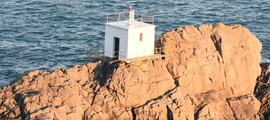 Guernesey : Petit bâtiment blanc sur la côte rocheuse.