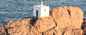 Guernesey : Petit bâtiment blanc sur la côte rocheuse.