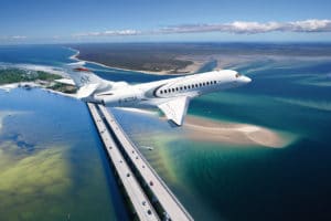 jet privé Falcon 6X en vol au-dessus de la mer