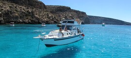 **Location de bateau Lampedusa : Bateau blanc près des falaises**