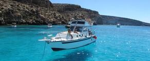 **Location de bateau Lampedusa : Bateau blanc près des falaises**