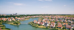 Cadzand quartier résidentiel avec rivière et verdure.