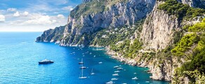 Capri entourée par des bateaux sur mer bleue.