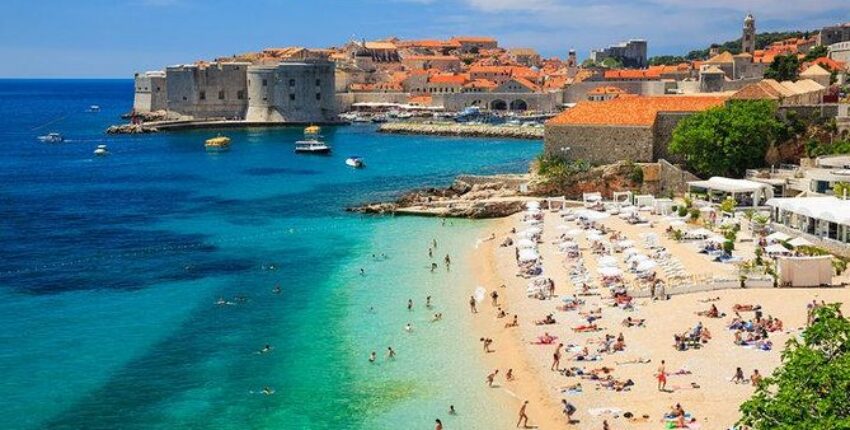 Croatie jet privé : plage ensoleillée avec fort médiéval.