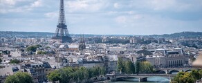 Vue aérienne Paris Seine ponts Tour Eiffel ciel partiellement nuageux.