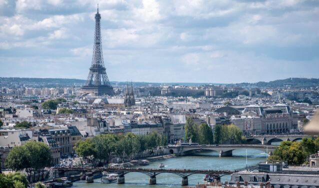Vue aérienne Paris Seine ponts Tour Eiffel ciel partiellement nuageux.
